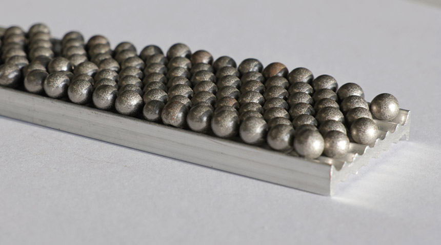 Le matériau composite HoverLIGHT est constitué d'un noyau en mousse d'aluminium avec des sphères creuses encapsulées. Leurs effets d'amortissement sont comparables à ceux du magnésium. Source : Fraunhofer IWU